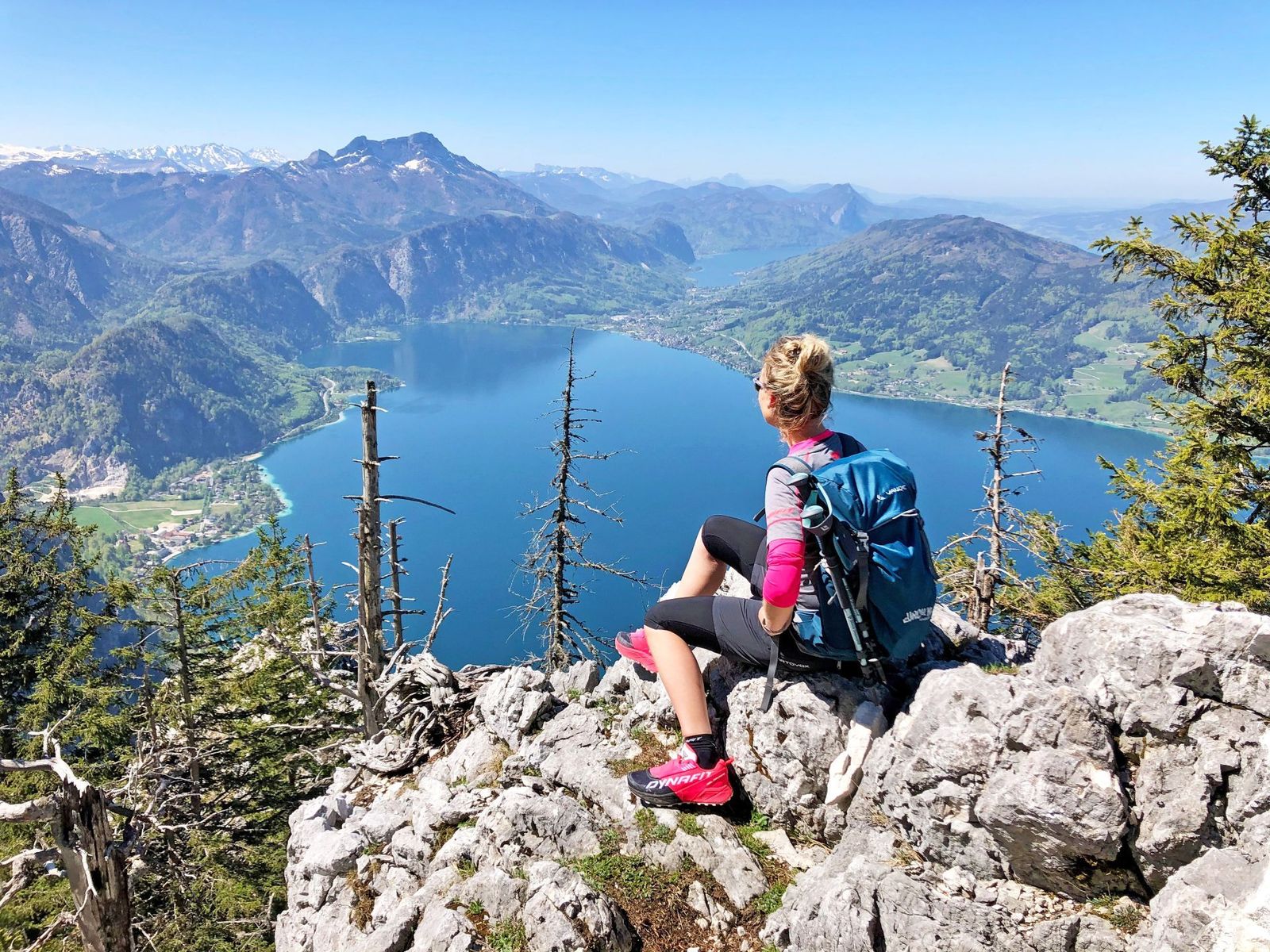 Hiker sits on a rocky outcrop looking down at Lake Attersee- supplied by Eurohike