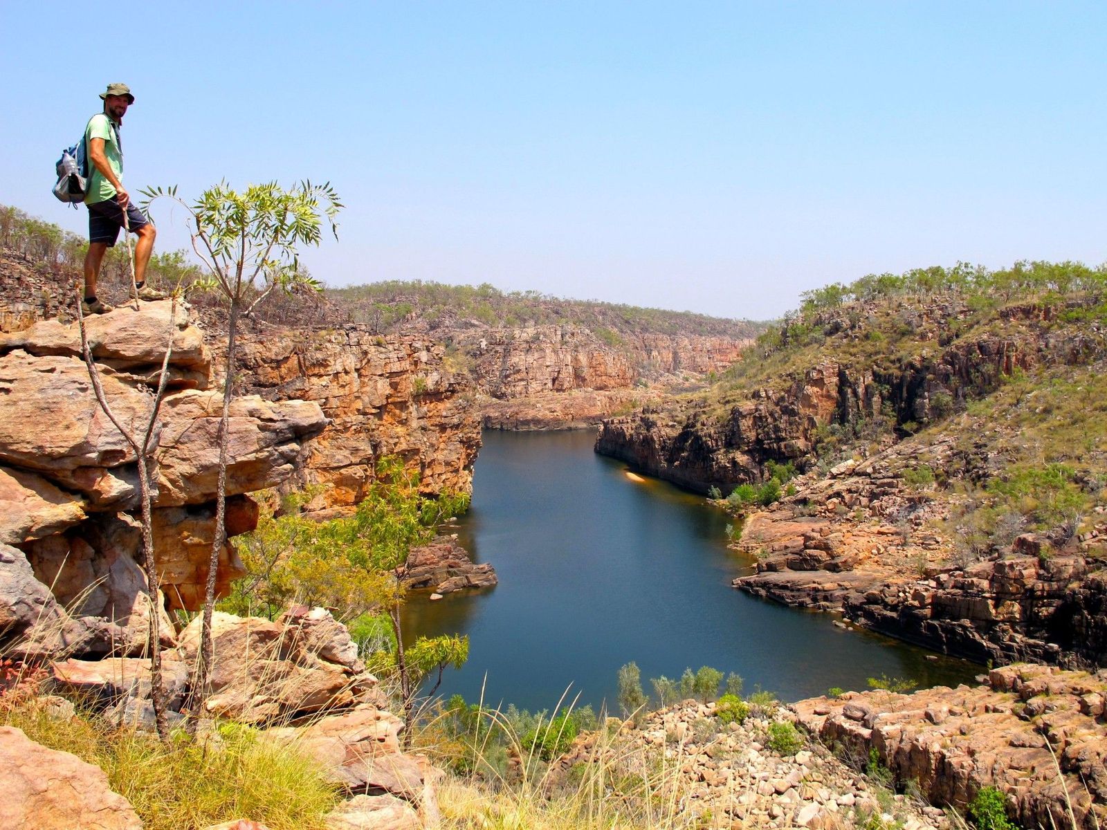 Hiker standing on the dramatic sandstone cliffs and winding river of Katherine Gorge in Nitmiluk National Park