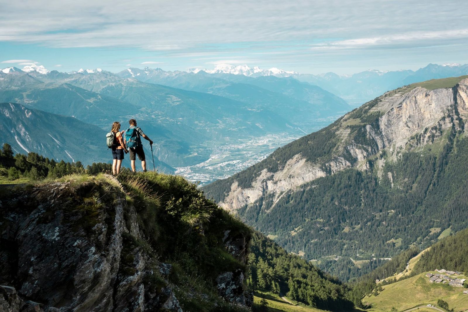 Hikers standing on a clifftop, looking out Pennine Alps near Leukerbad in the Valais canton of Switzerland-supplied by Eurotrek