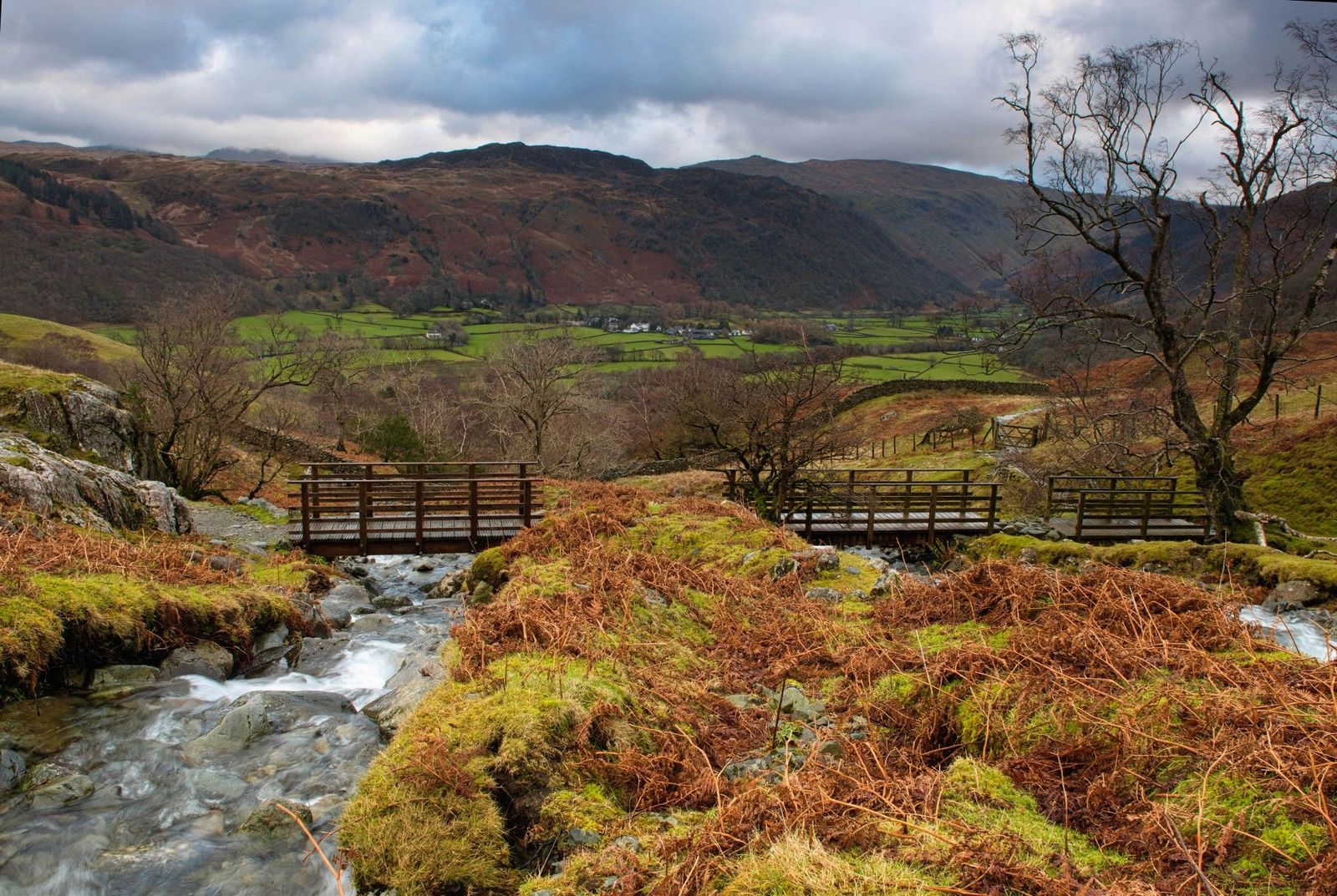 Wooden footbridges crossing a rushing mountain stream near Castle Crag
