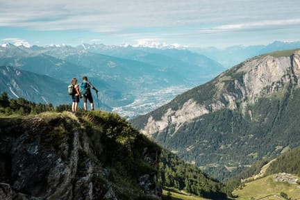 Hikers standing on a clifftop, looking out Pennine Alps near Leukerbad in the Valais canton of Switzerland-supplied by Eurotrek