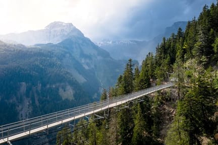 Pedestrian suspension bridge in a forested gorge along the Bisse du Ro hiking trail near Crans-Montana, Switzerland- supplied by Eurotrek
