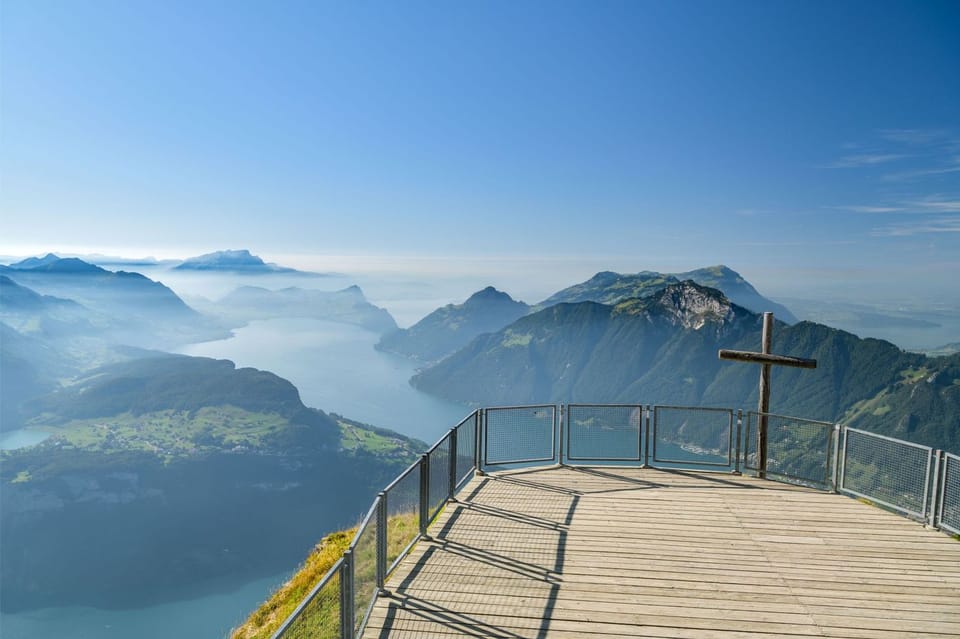 Wooden viewing platform and summit cross on top of the Fronalpstock peak near Stoos village